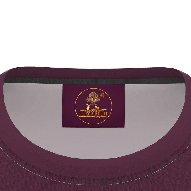 Close-up of a purple maroon cotton tshirt garment with a gold and maroon label logo of Elizabeth's Boutique by designer Elizabeth Shewan artist on a white background