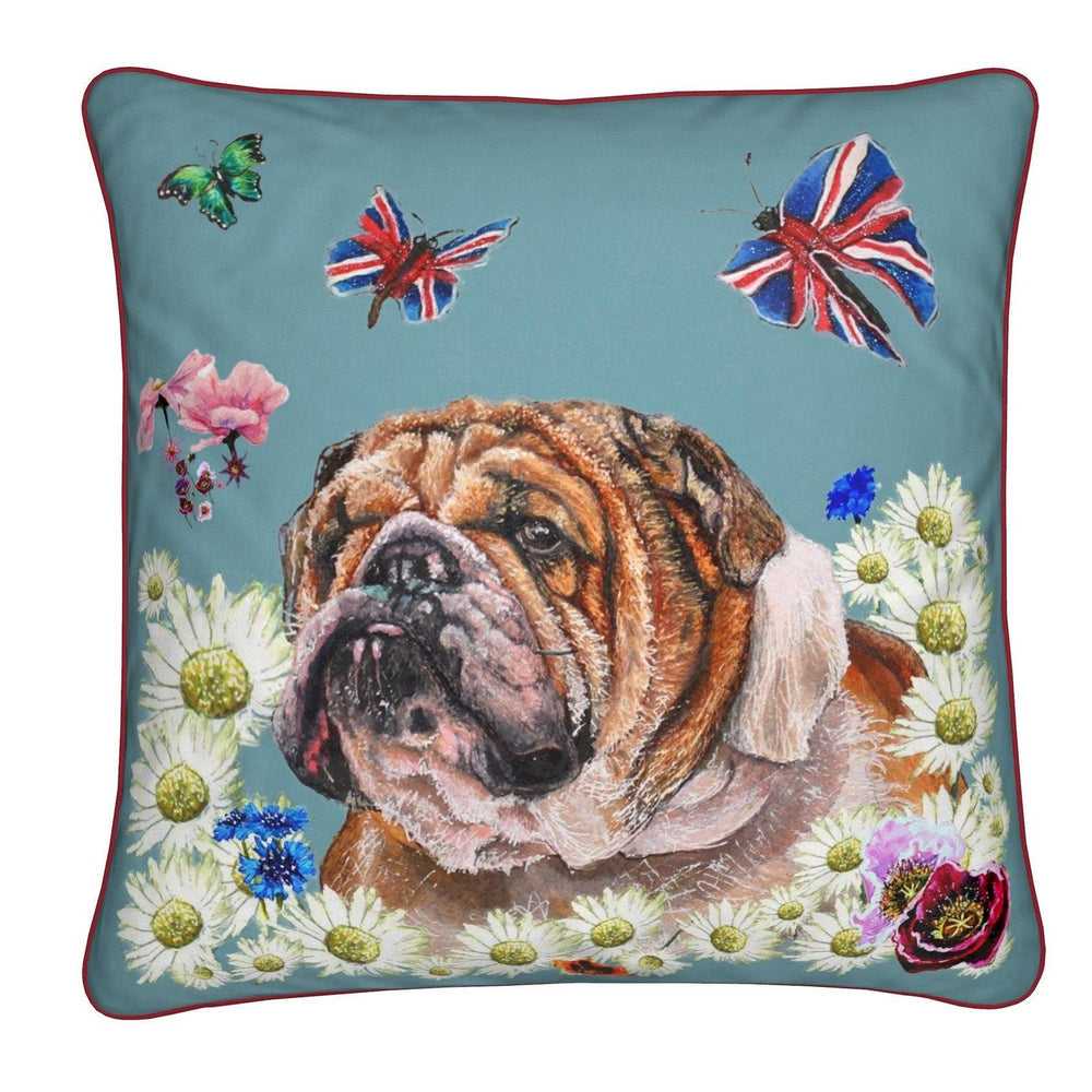 A square decorative throw pillow featuring a detailed illustration of an English Bulldog surrounded by white daisies, blue flowers, butterflies, and Union Jack-themed butterflies on a teal-blue background with a red piped edge.