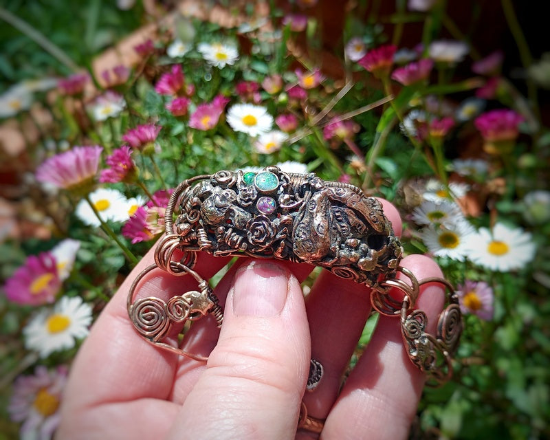 Decorative bracelet held in front of a floral background