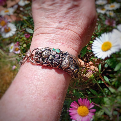Decorative ring on a wrist with flowers in the background