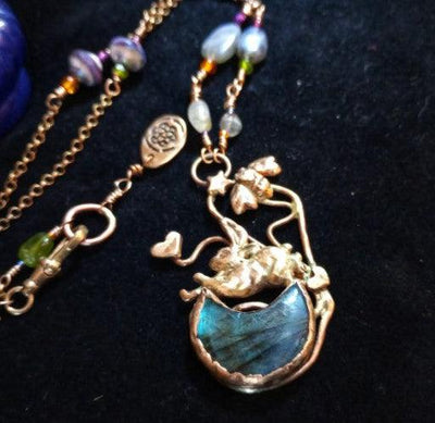 Necklace with a blue pendant and gold accents on a dark background