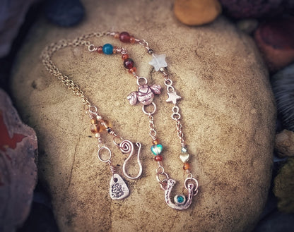 Necklace with various charms on a stone surface