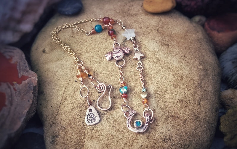 Necklace with various charms on a textured stone surface