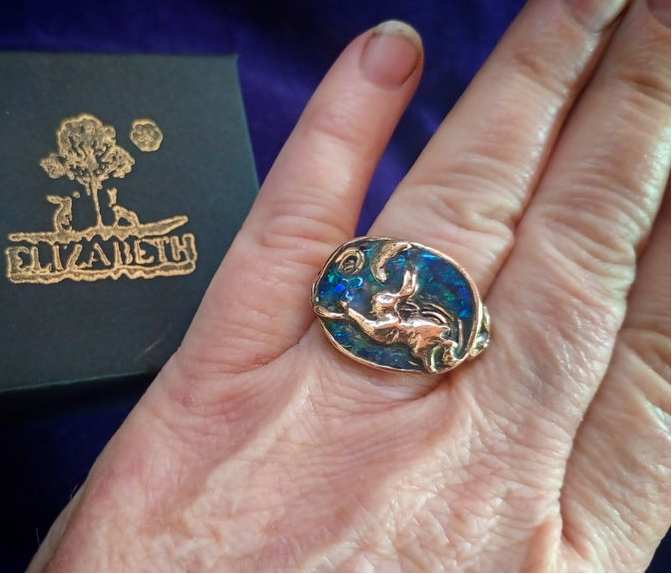 Gold ring with blue stone on a hand, Elizaveta box in the background