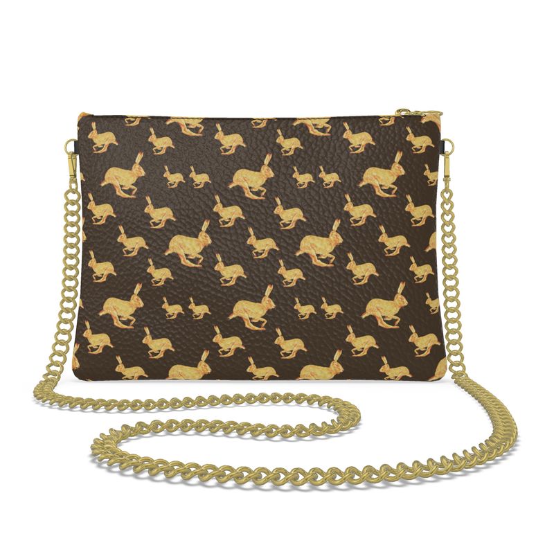 Handbag with gold rabbit pattern and gold chain strap on a white background