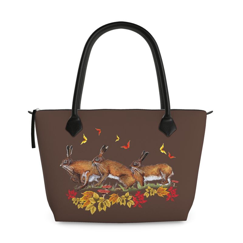 Brown handbag with hare rabbit butterfly and leaf design on a white background