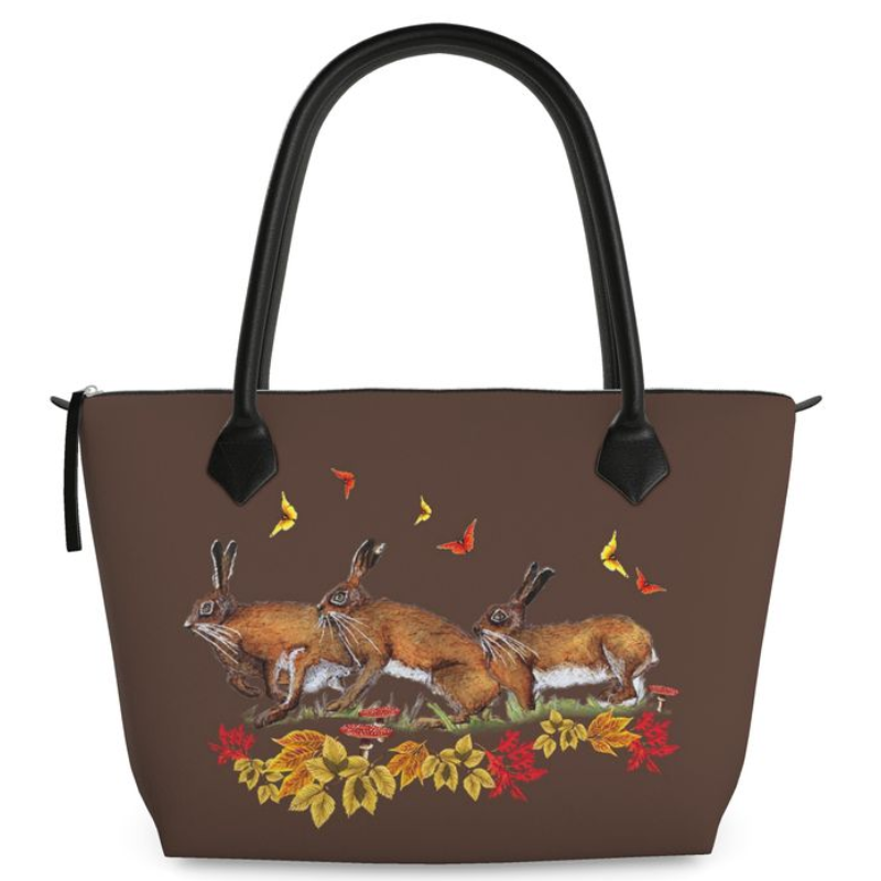 Brown handbag with hare butterfly rabbit and leaf design on a white background