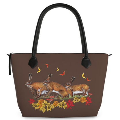 Brown handbag with hare butterfly rabbit and leaf design on a white background