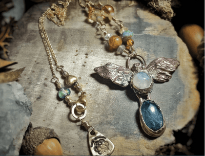 Necklace with angel pendant and gemstones on a wooden surface